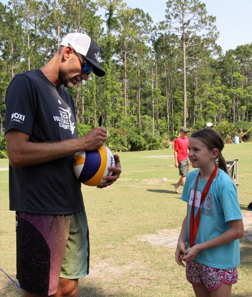 Olympic gold medalist Phil Dalhausser autographs a volleyball for Lauren Boots during a recent youth volleyball class presented by Volleyball1on1 in Nocatee Community Park.